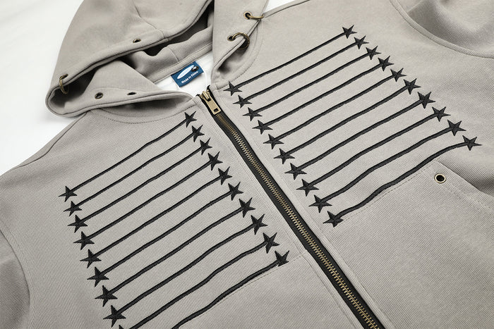 Close-up of the gray hoodie upper front showing the drawstring hood, zipper, and symmetrical star-and-stripe embroidery