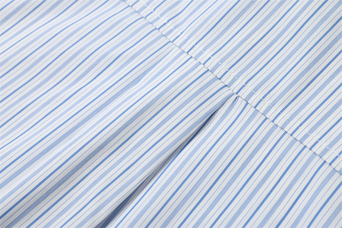 Pleated back yoke detail on a light blue and white striped shirt