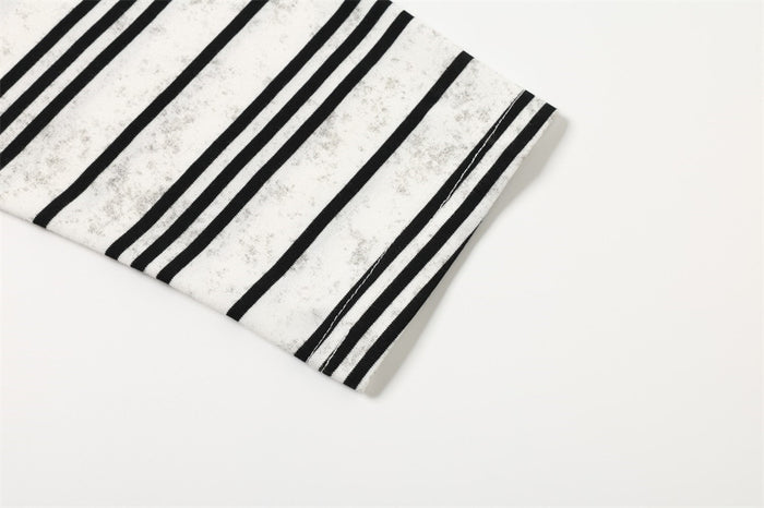 Close-up of white sleeve cuff with black stripes