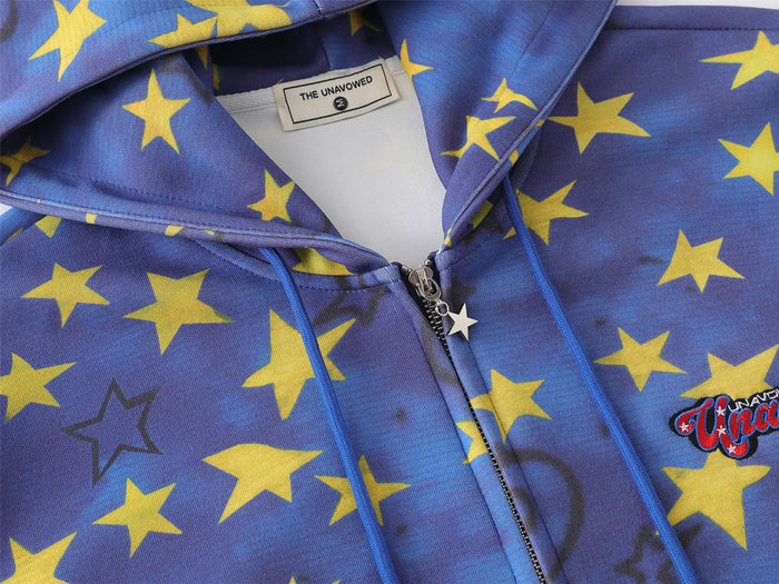 Close-up of blue star-print hoodie label, drawstrings, zipper pull, and embroidered script logo