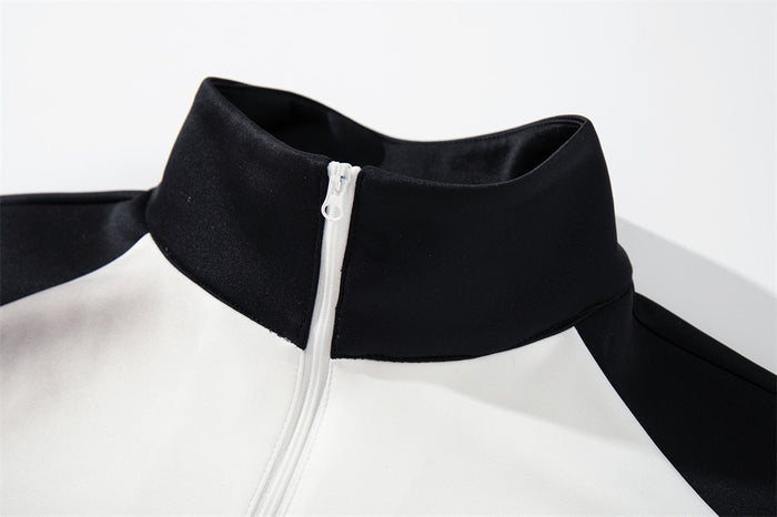 Close-up of the black mock neck and white front zipper on a smoke-dyed track jacket