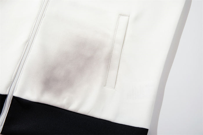 Close-up of the white smoke-dyed jacket front showing a vertical zip pocket and black ribbed hem