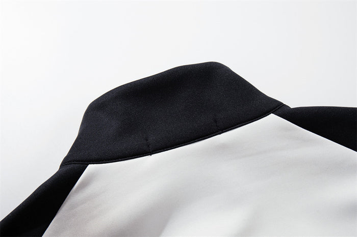 Close-up of the black mock-neck collar, raglan seam and white jacket fabric
