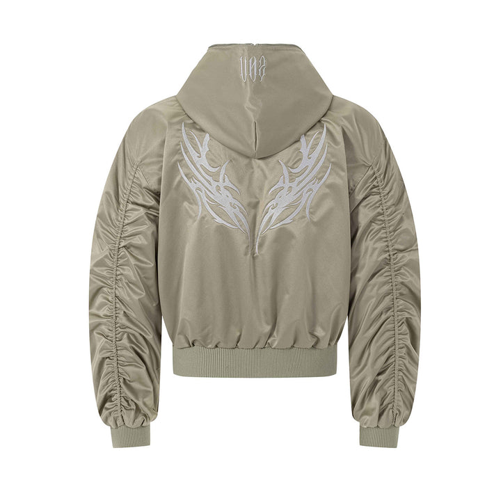 Back view of beige hooded bomber jacket with large embroidered wing-like graphic and gathered sleeves