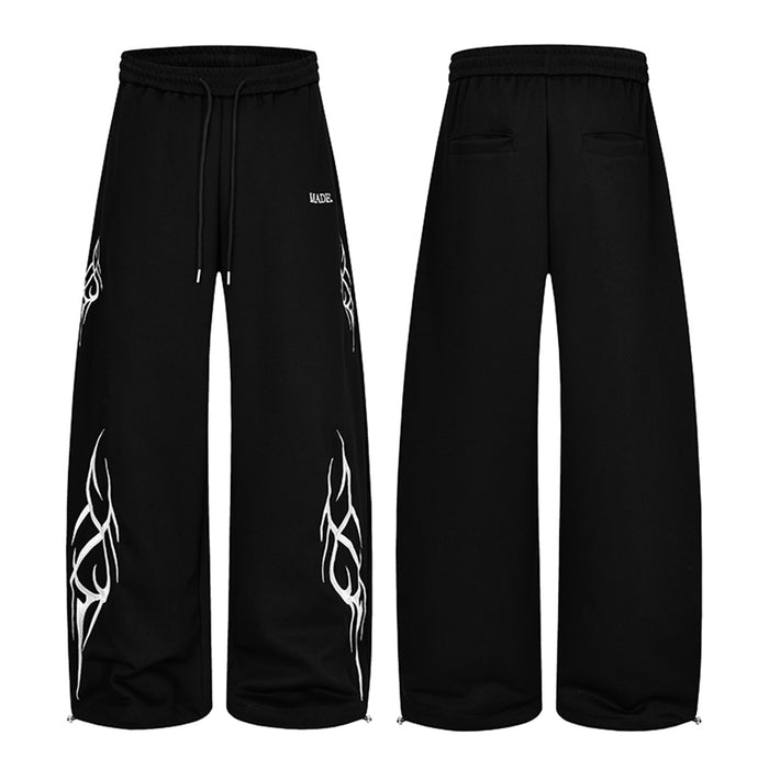 Black wide-leg sweatpants shown front and back with white abstract tribal graphics, drawstring waist, and rear pockets