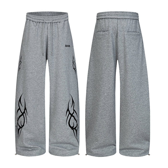 Heather gray wide-leg sweatpants shown front and back with black abstract tribal graphics and drawstring waist