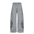Front view of heather gray wide-leg sweatpants with black abstract tribal graphics and drawstring waist