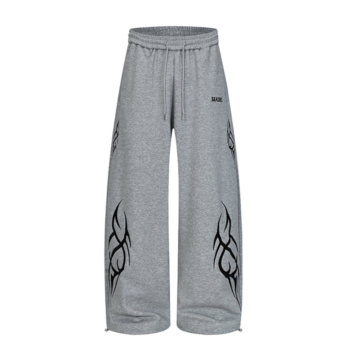 Front view of heather gray wide-leg sweatpants with black abstract tribal graphics and drawstring waist