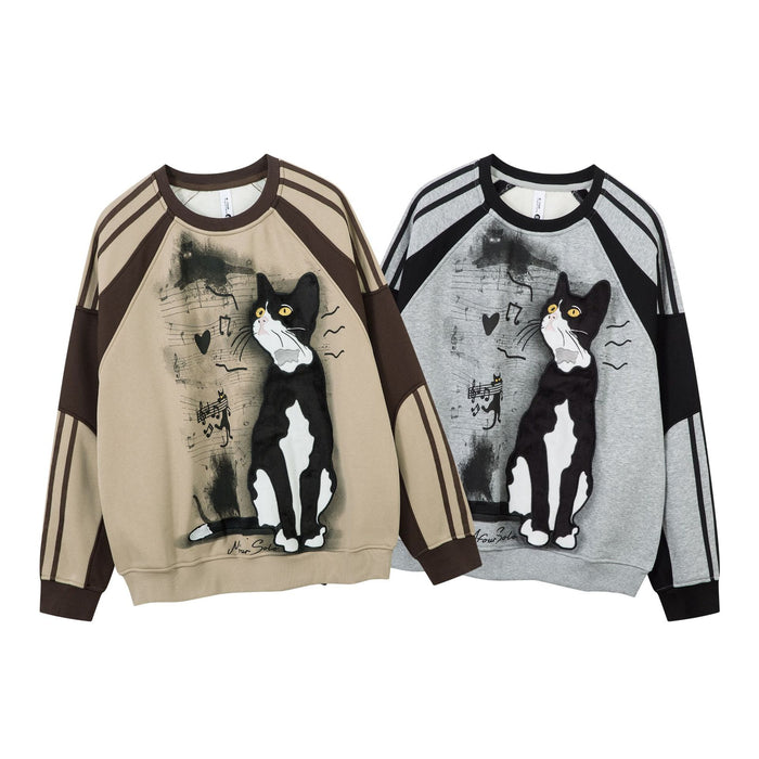 Front view of beige and gray tuxedo cat sweatshirts with black-and-brown colorblock raglan sleeves