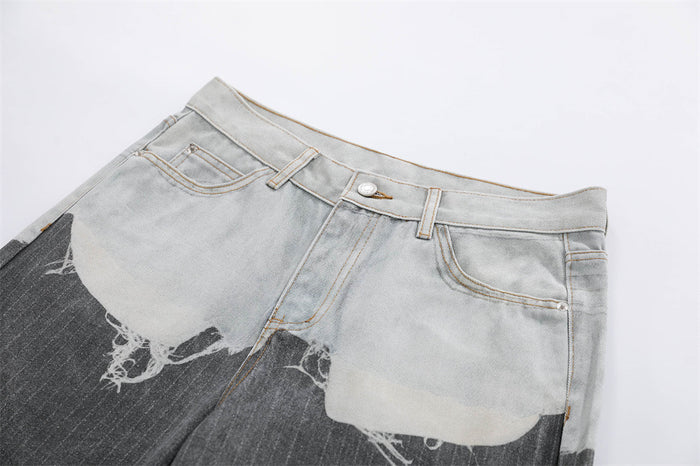 Close-up of front waist on two-tone distressed jeans with button closure and contrast wash