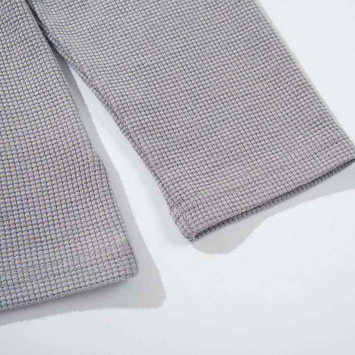 Close-up of light gray waffle knit long sleeve cuff and sleeve texture