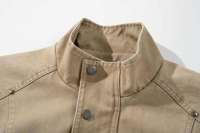 Close-up of the washed khaki jacket's stand collar, snap button closure and detailed shoulder stitching