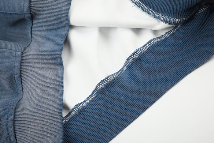 Close-up of the blue hoodie interior edge showing fabric layers and neatly finished seam stitching