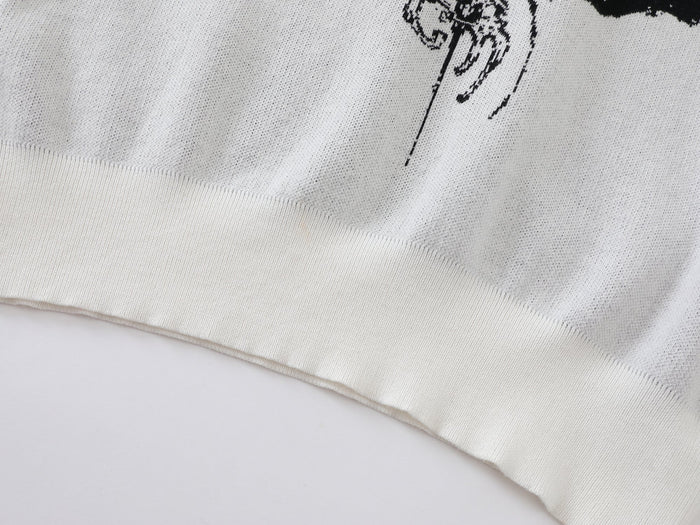 Close-up of white knit sweater hem showing ribbed cuff and knit texture