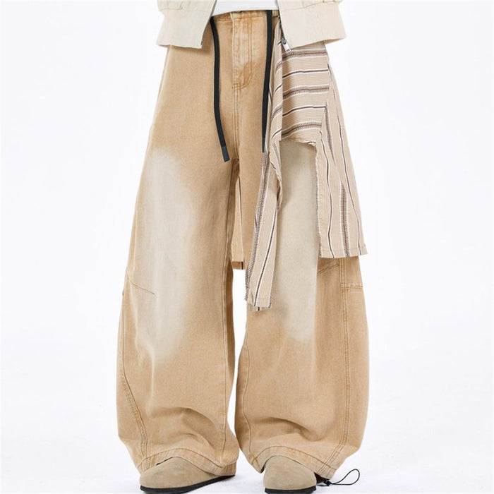 Front model view of tan baggy jeans with striped detachable overlay and black drawstrings