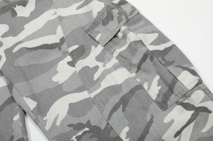 Close-up of a grey camouflage cargo pocket with flap, stitching, and side panel construction