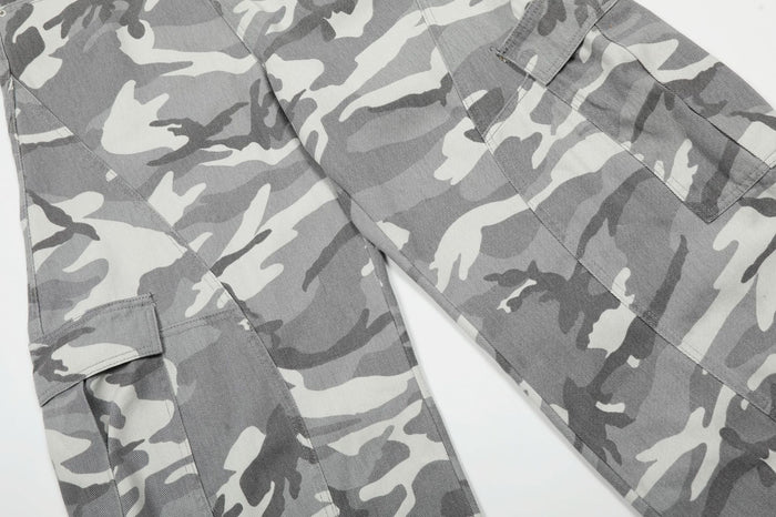 Detailed view of grey camouflage cargo pants legs showing flap pockets and wide-leg tailoring