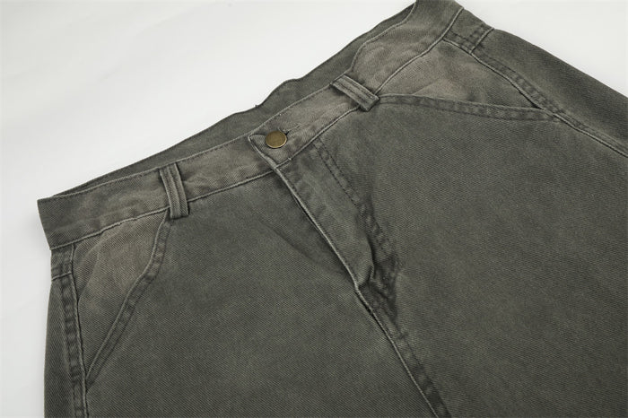 Close-up of olive green cargo pants waistband and front pocket stitching with metal button