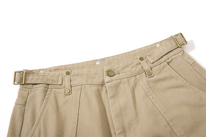 Close-up of khaki cargo pants waistband with belt loops, button closure, and side buckle strap
