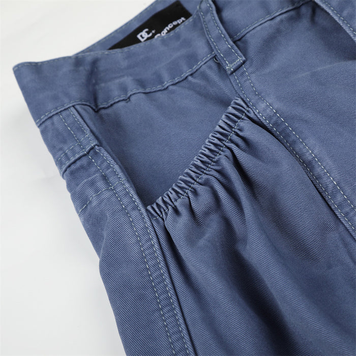 Close-up of blue cargo pants side pocket with elastic gathering and top stitching