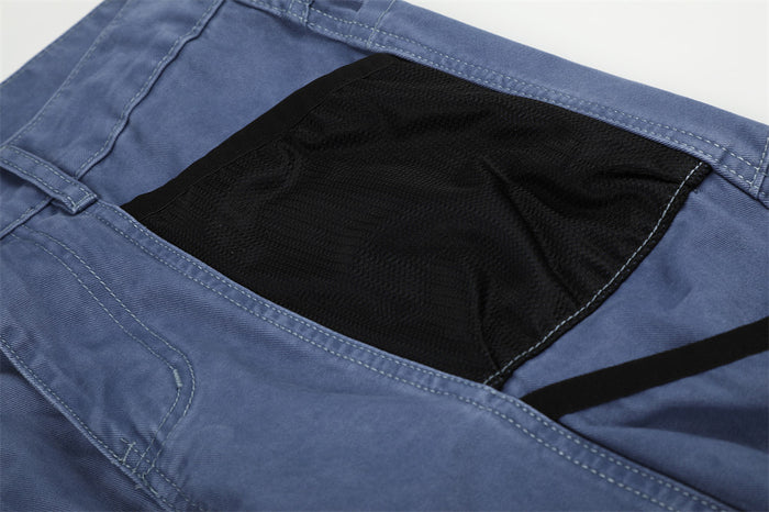 Close-up of blue cargo pants black mesh side pocket panel
