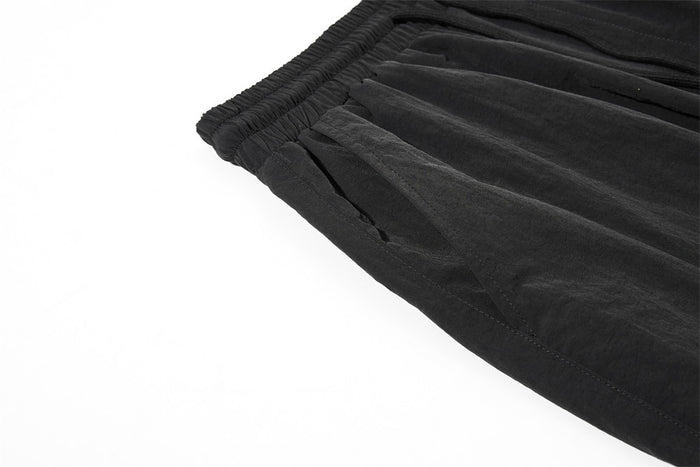Close-up of black cargo sweatpants leg with wide hem and side seam