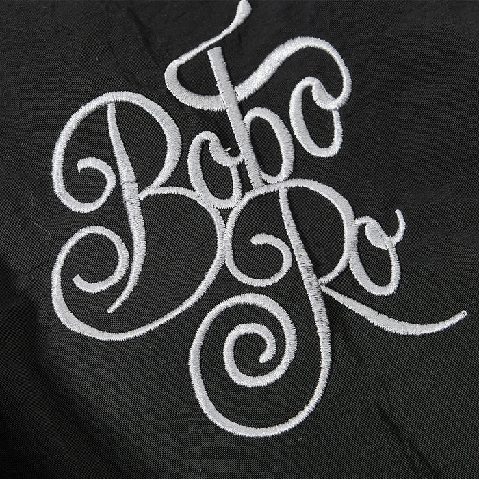 Close-up of white embroidered logo on black cargo sweatpants