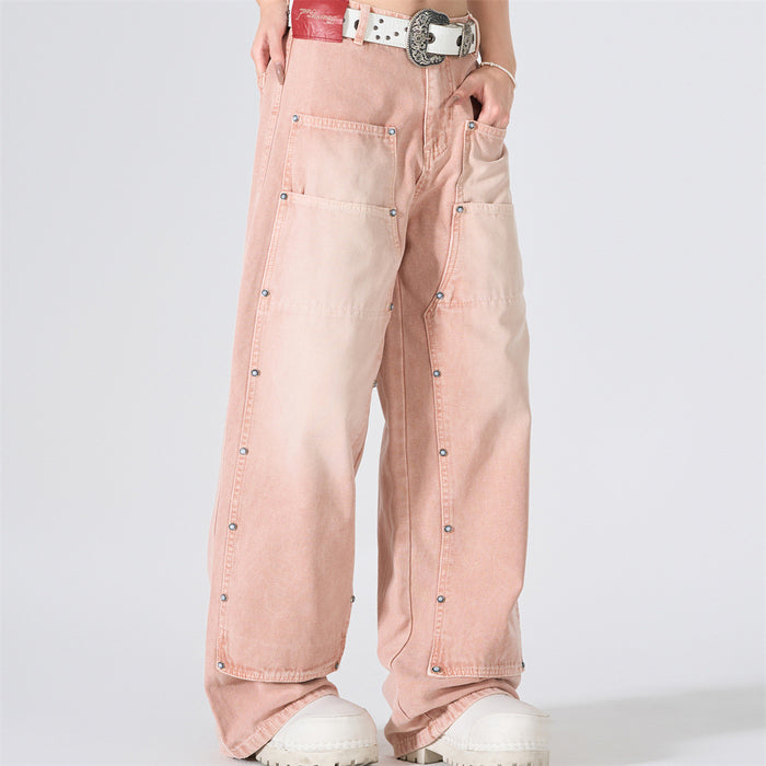 Front angled view of pink washed wide-leg carpenter jeans with oversized patch pockets and stud details