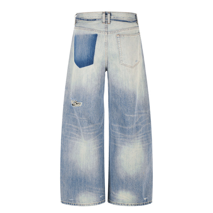 Back view of wide-leg distressed jeans with faded wash and rip at knee