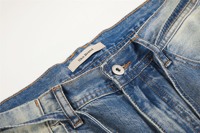 Close-up of denim waistband with button fly, belt loops, and brand label