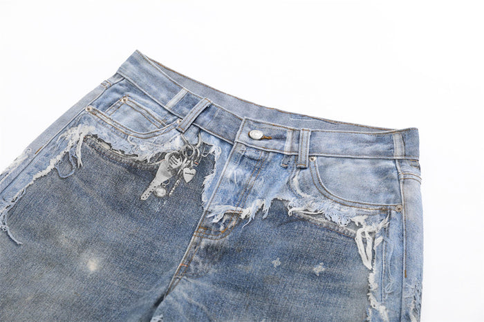 Close-up of front waistband and pockets on distressed blue jeans with heavy fraying