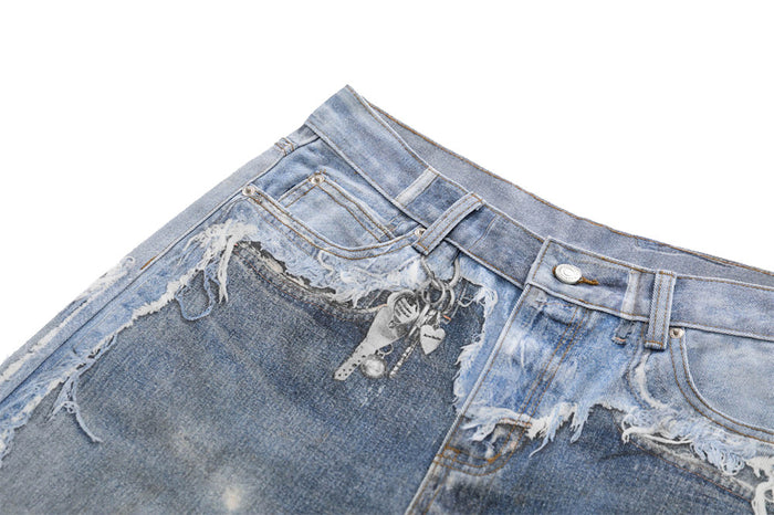 Close-up of front waistband and pocket area on wide-leg washed denim jeans with raw-edge distressing