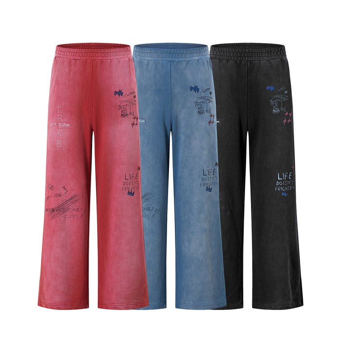 Front view of wide-leg acid-wash sweatpants in pink, blue, and black with graffiti-style graphics
