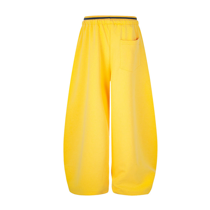 Back view of yellow wide-leg sweatpants showing a single rear patch pocket and elastic drawstring waistband