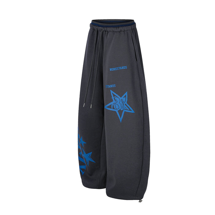Angled front view of charcoal wide-leg sweatpants with blue star emblem, lettering, and hanging drawstrings