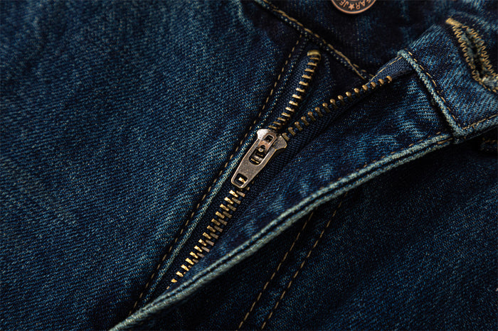 Close-up of jeans fly with metal zipper and dark blue denim trim