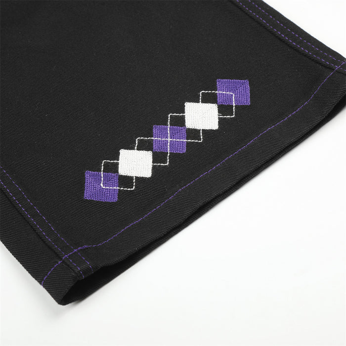 Hem detail of black jeans with purple and white diamond patch embroidery