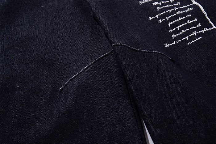 Close-up of dark indigo jeans crotch seam and small section of white script print
