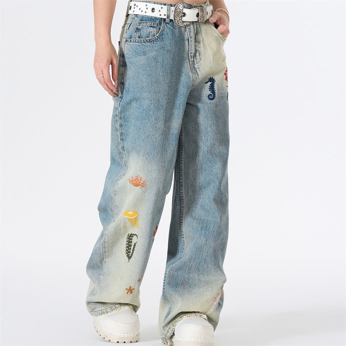 Model wearing wide-leg gradient wash jeans with ocean embroidery, front view