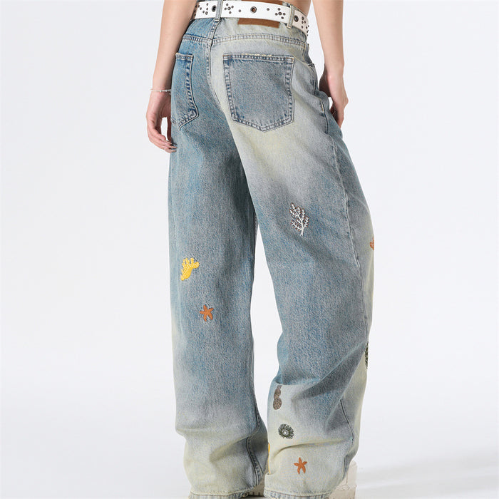 Model wearing wide-leg gradient wash jeans with ocean embroidery, back view