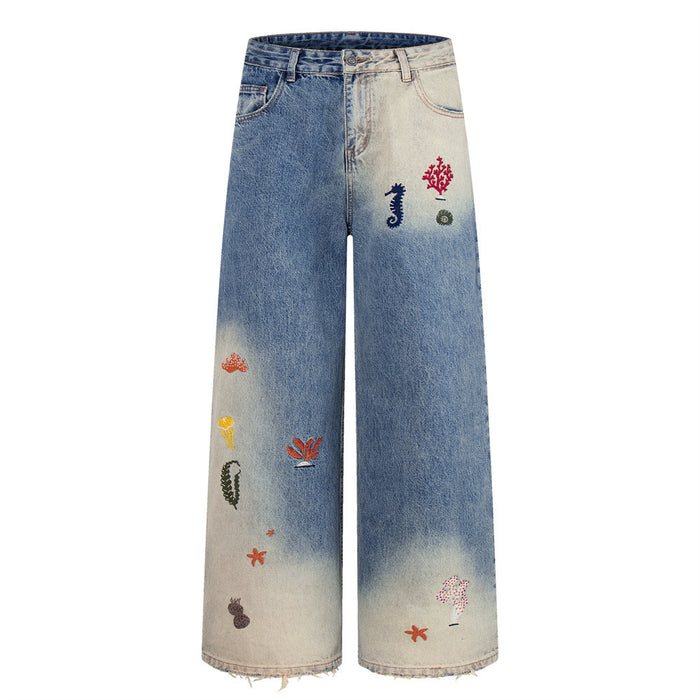 Front flat lay of wide-leg jeans with ocean embroidery and faded blue gradient wash