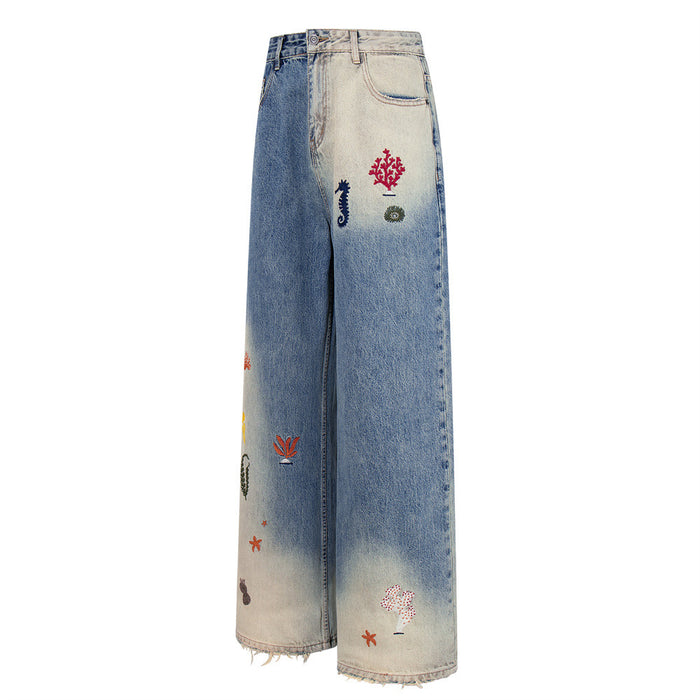 Side view of wide-leg jeans with ocean embroidery and faded blue gradient wash