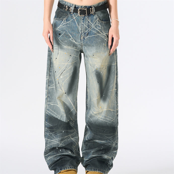 Front view of wide-leg blue jeans with white splatter scratch print and black belt