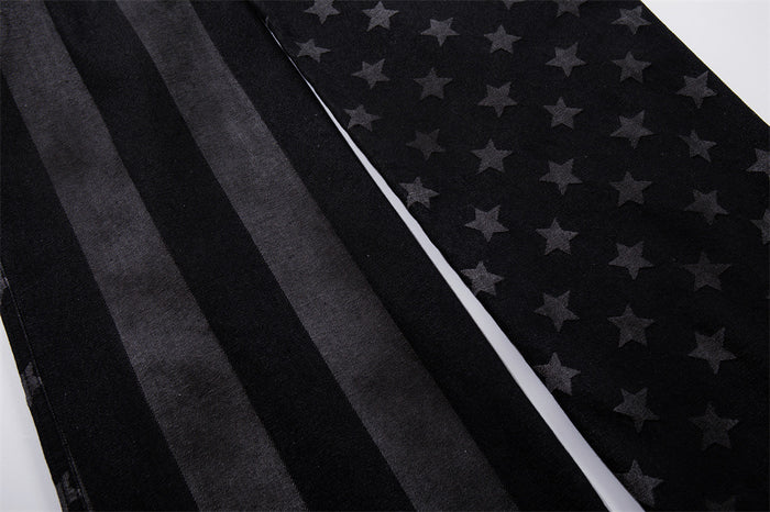 Close-up of wide pant legs showing vertical stripes and star print on black denim