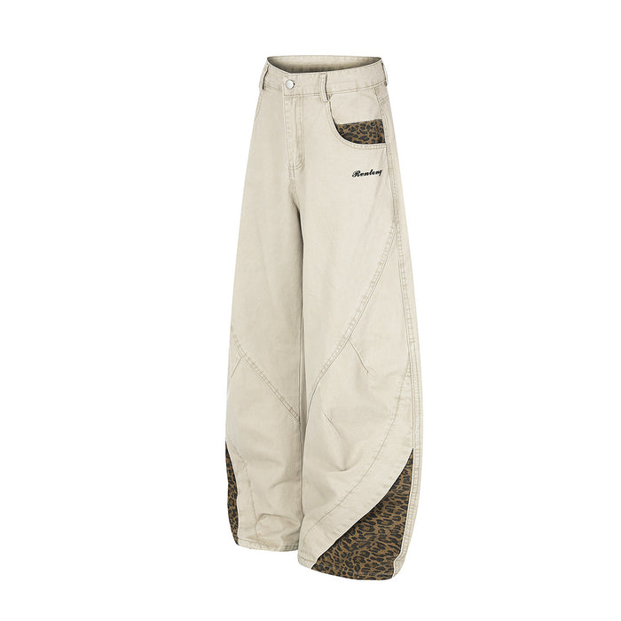 Three-quarter front view of beige wide-leg pants with leopard-print pockets and lower-leg side panels