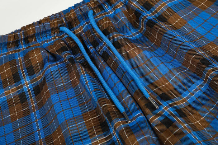 Close-up of the blue drawstring threaded through the gathered waistband of the plaid pants