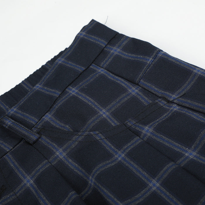 Close-up of the waistband and upper front pocket area on plaid trousers