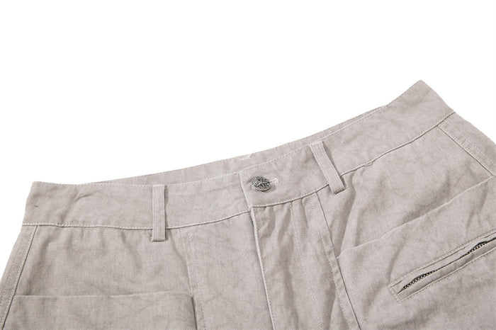 Close-up of light gray pants waistband with button and belt loops