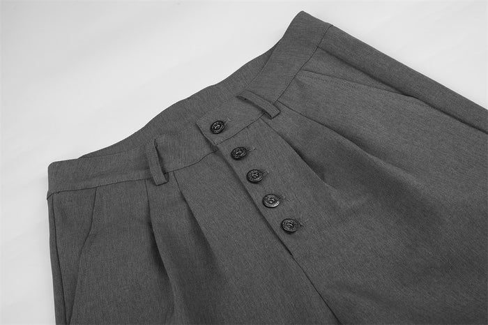 Close-up of gray pleated waistband and metal button fly on dress pants
