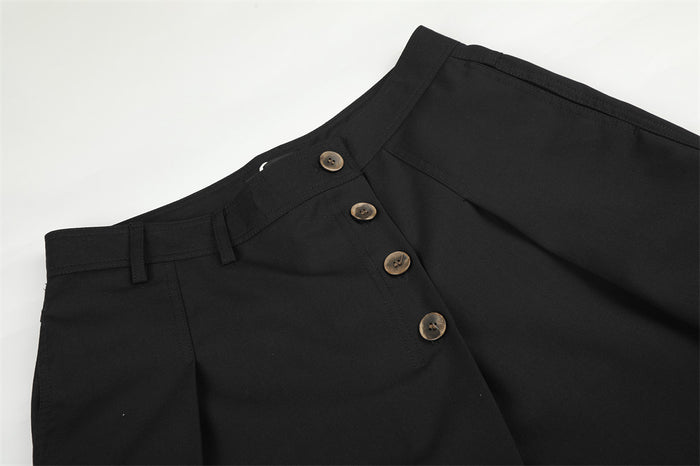 Black trousers waist close-up with diagonal button fly and belt loops